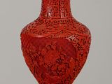 un vase rouge avec un couvercle bleu posé sur une table