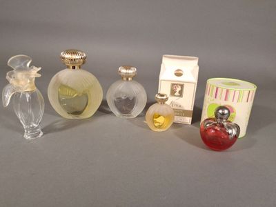 cinq flacons de parfum différents posés les uns à côté des autres sur une table
