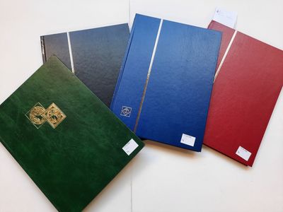 quatre cahiers de couleurs différentes posés sur une table blanche