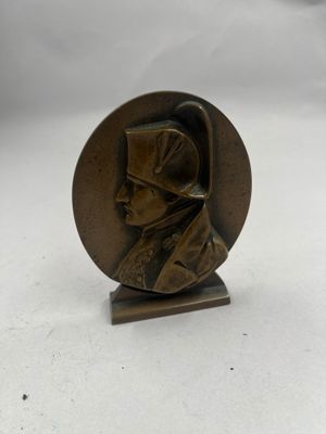 un gros plan sur une statue en bronze représentant un homme coiffé d'un chapeau