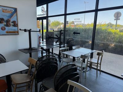 de nombreuses tables et chaises dans un restaurant donnant sur la rue