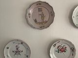 four plates on the wall that are decorated with flowers