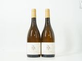 deux bouteilles de vin posées l'une à côté de l'autre sur une surface blanche