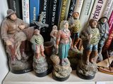 de nombreuses figurines représentant des personnes, posées sur une étagère