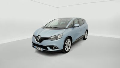 Une voiture bleue est garée dans une pièce blanche au sol blanc.