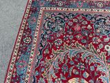 an image of a red and blue rug with a cat laying on it