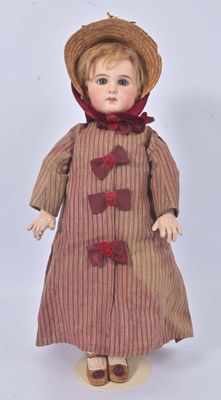 a small doll that is wearing a hat and dress