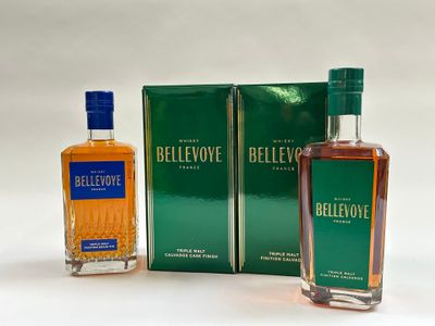 deux bouteilles d'alcool posées l'une à côté de l'autre sur une table