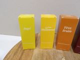 three boxes of perfume sitting on top of a wooden table