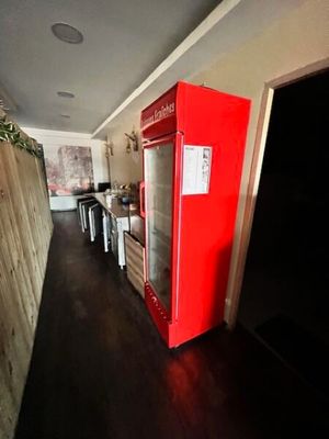 un réfrigérateur rouge qui se trouve au milieu d'une cuisine