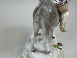 a figurine of a boy riding a horse