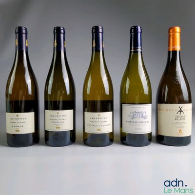 four bottles of wine are lined up on a table