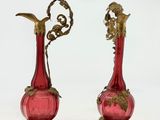 paire de vases en verre rouge rehaussés de touches dorées sur fond blanc
