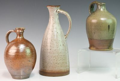 trois vases posés l'un à côté de l'autre sur une table