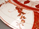 a red and white plate with a floral design on it
