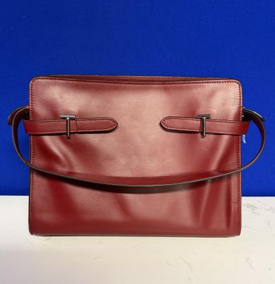 a red leather purse sitting on top of a white table