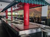 a restaurant kitchen with a long counter and a red roof