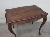 a small table with a wooden top on a cement floor
