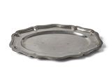 assiette argentée à bord festonné sur fond blanc