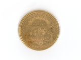 une pièce d'or sur une surface blanche avec un fond blanc