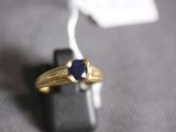 an image of a gold ring with a blue stone