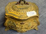 gold plated box with a price tag on it sitting on a blue cloth