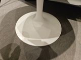 a white table with a glass top on a carpeted floor