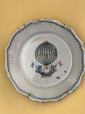 une assiette sur laquelle est peint une montgolfière