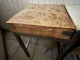 a small table with a wooden top in the corner of a room