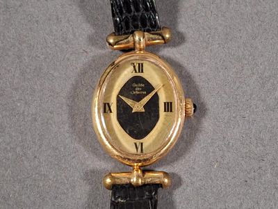 Montre bracelet de dame à boîtier ovale en métal doré.