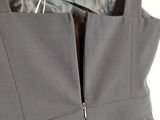 the back of a dress hanging on a hanger in a closet