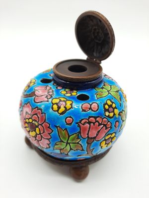 un petit vase bleu orné de fleurs peintes