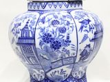 un vase bleu et blanc avec un couvercle posé sur une table