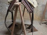 une selle de cheval posée sur un support en bois dans une pièce