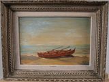 tableau représentant un bateau rouge sur une plage de sable, dans un cadre argenté