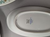 a white toilet with a white lid and a white bowl with a flower design on it