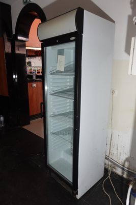 un réfrigérateur qui se trouve dans le coin d'une pièce