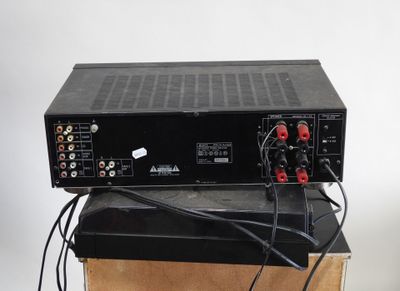 a close up of a black amplifier sitting on top of a wooden box