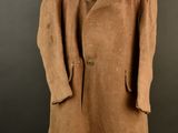 a brown coat on a mannequin stand against a black background