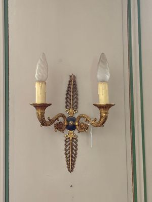 une applique murale fixée au mur à côté d'un miroir