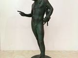 bronze statue of a man holding a knife and pointing at something