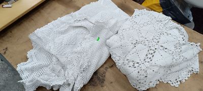 two pieces of white crocheted clothing on a table