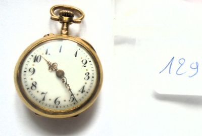 une montre de poche posée sur une feuille de papier, à côté d'une autre feuille de papier
