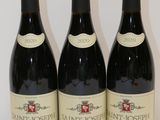 three bottles of wine are lined up on a white surface