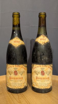 two bottles of wine sitting on top of a table next to each other