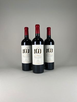 three bottles of red wine sitting on top of a table