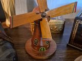a small wooden windmill on a table next to a pair of shoes