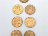 five different types of gold coins on a white surface