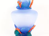 a glass vase with a blue and orange decoration on it