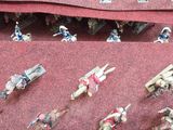 many figurines of people riding motorcycles on a red cloth